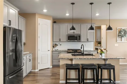 a kitchen with stainless steel appliances granite countertop a refrigerator a sink and a stove