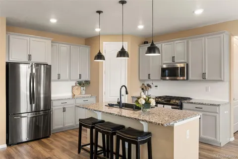 a kitchen with stainless steel appliances granite countertop a refrigerator a stove a sink and a refrigerator