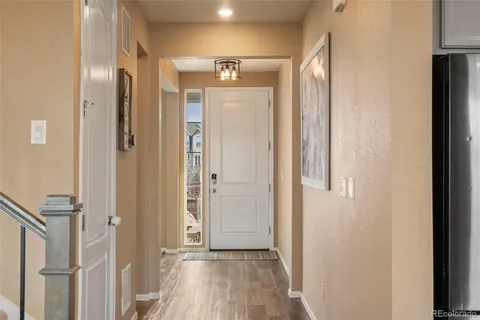 a view of a hallway with wooden floor and staircase