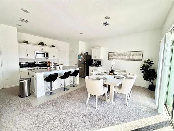 a view of a dining room with furniture and a kitchen