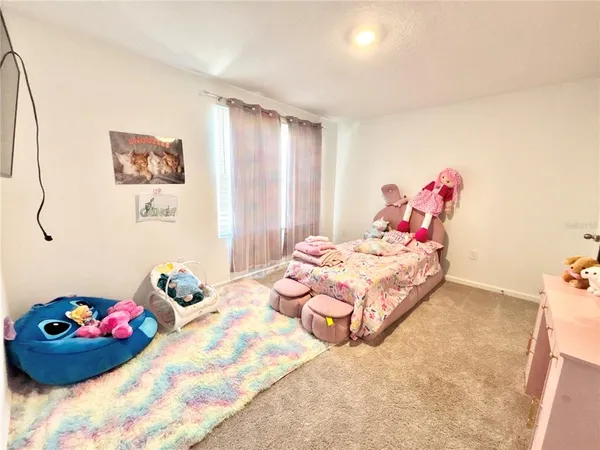a bedroom with a bed and a painting on the wall