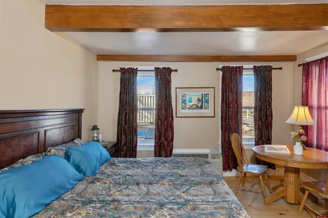 a large bed in a bedroom next to a window