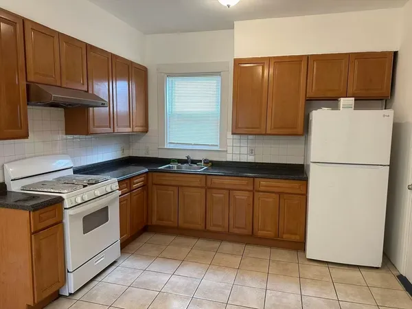 a kitchen with a refrigerator sink and cabinets