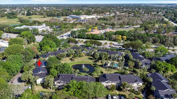 an aerial view of residential houses with outdoor space and trees