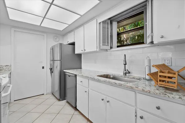 a kitchen with stainless steel appliances granite countertop a sink a refrigerator and a granite counter tops
