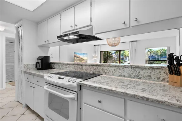 a kitchen with granite countertop cabinets stainless steel appliances and a counter space