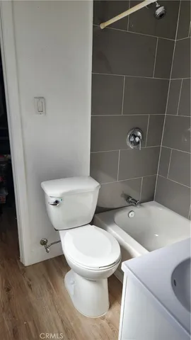 a white toilet sitting next to a bath tub