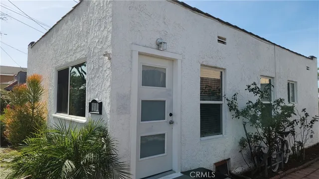 a front view of a house with plants