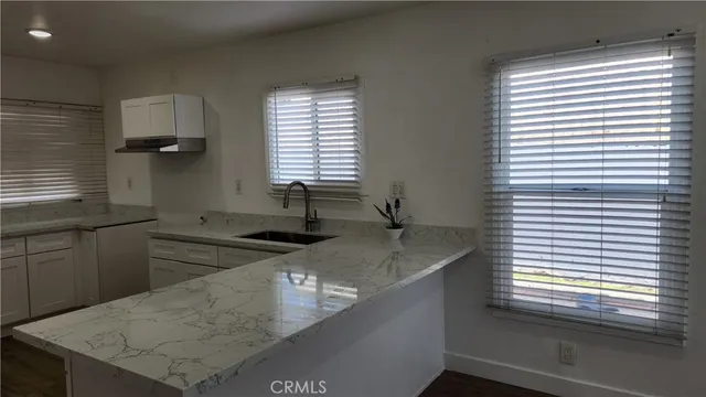 a kitchen with stainless steel appliances granite countertop a sink a stove and a window