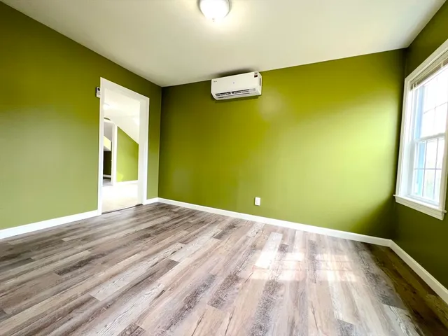a view of a big room with wooden floor and windows