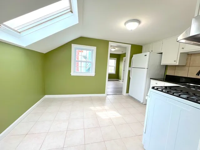 a view of kitchen with furniture and refrigerator