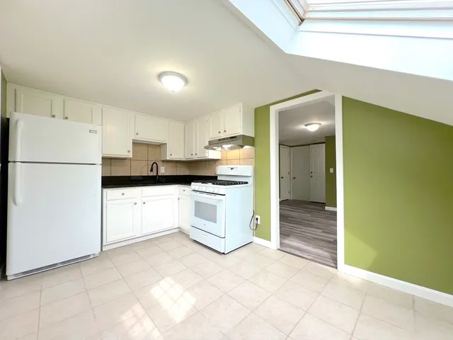 a kitchen with a refrigerator and a stove top oven