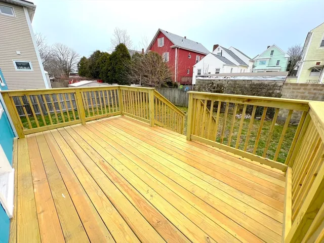 a view of a balcony with wooden floor and iron stairs