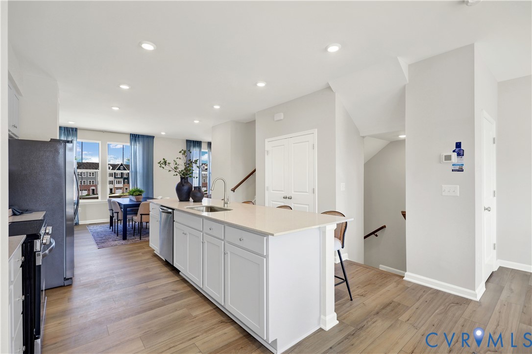 6047 Blue Iris Road Richmond, VA 23225 - Photo 6 of 27 a open kitchen with stainless steel appliances granite countertop a lot of counter space and wooden floor