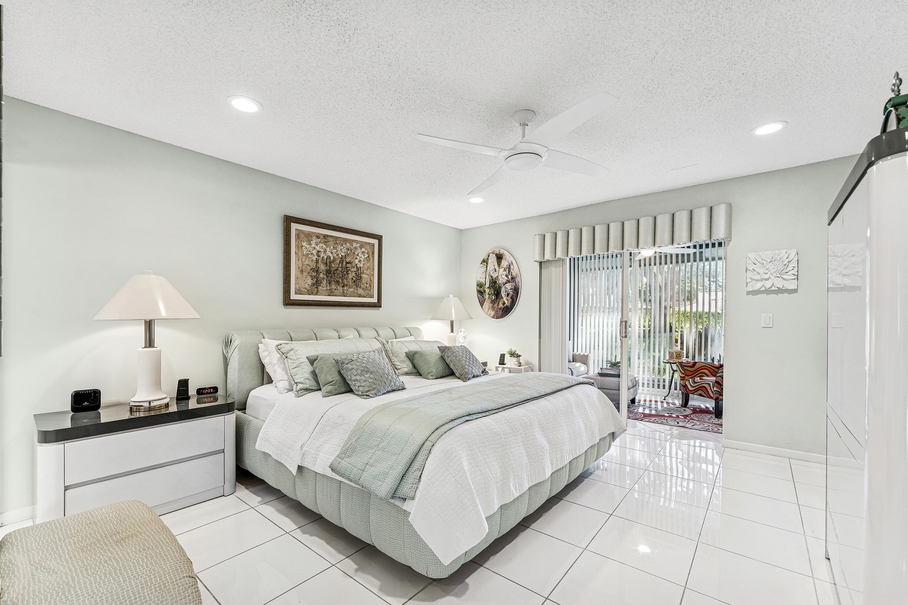 6348 Pointe Pleasant Circle Delray Beach, FL 33484 - Photo 18 of 40 a bedroom with a large bed and a chandelier