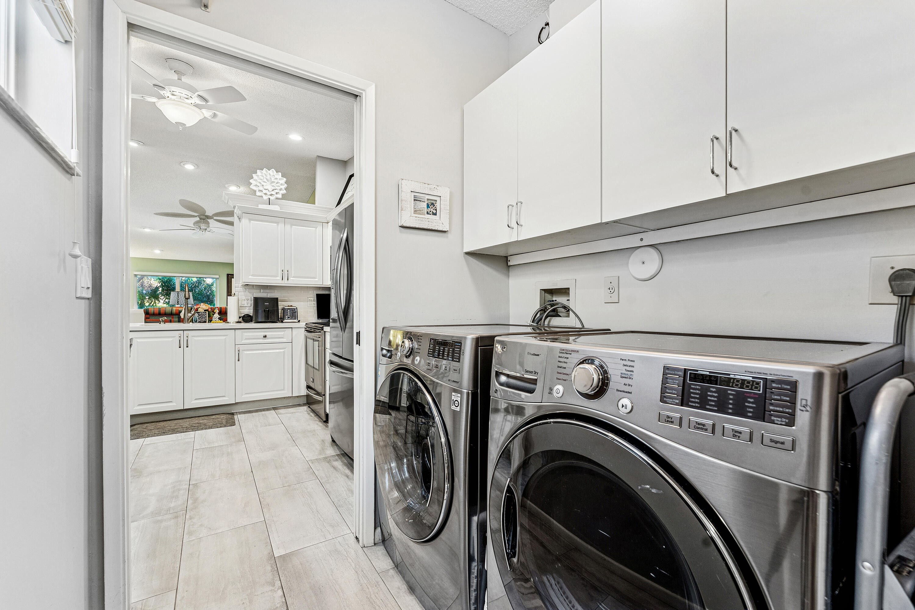 6348 Pointe Pleasant Circle Delray Beach, FL 33484 - Photo 23 of 40 a view of washer and dryer with kitchen in the background