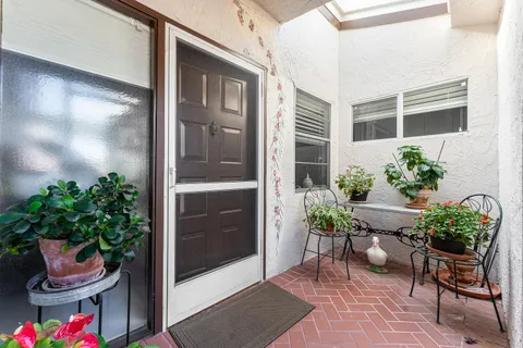 a view of a porch with chairs and a potted plant