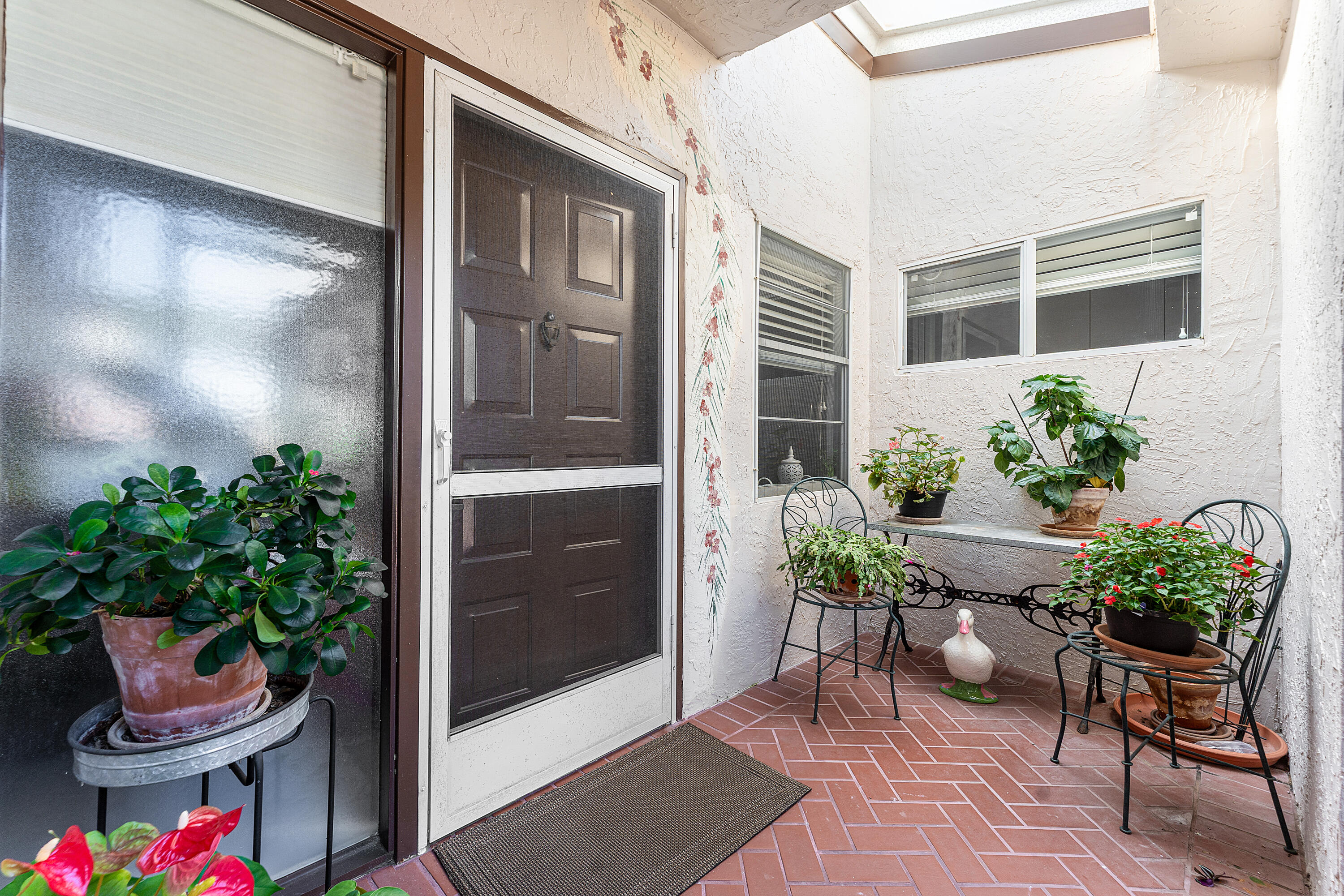 6348 Pointe Pleasant Circle Delray Beach, FL 33484 - Photo 4 of 40 a view of a porch with chairs and a potted plant
