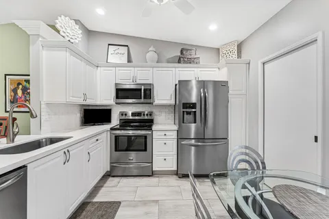 a kitchen with stainless steel appliances granite countertop a refrigerator and a stove top oven