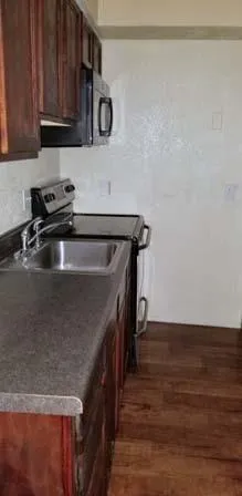 a kitchen with kitchen island a sink and wooden cabinets