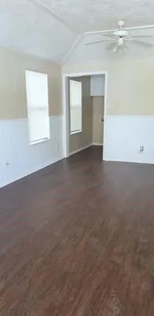a view of an empty room with wooden floor