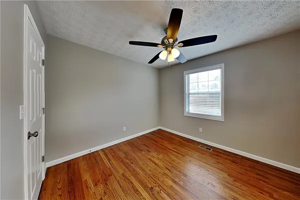 an empty room with a window and a fan