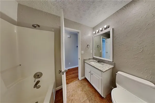 a bathroom with a granite countertop sink toilet and shower