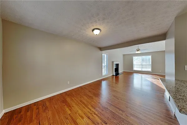 a view of empty room with wooden floor and fireplace