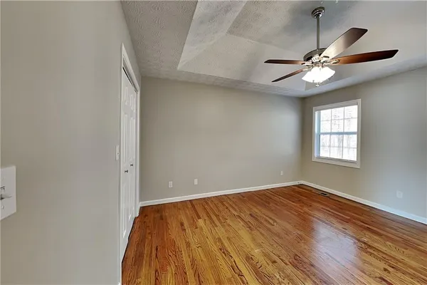 a view of empty room with wooden floor