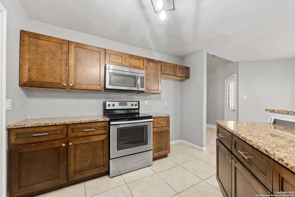 a kitchen with stainless steel appliances granite countertop a stove a sink and a microwave