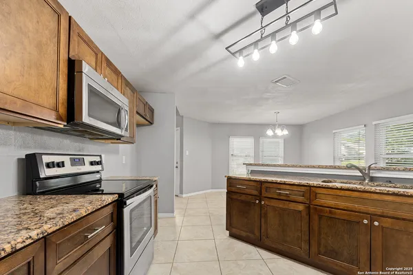 a kitchen with stainless steel appliances granite countertop a sink and stove top oven