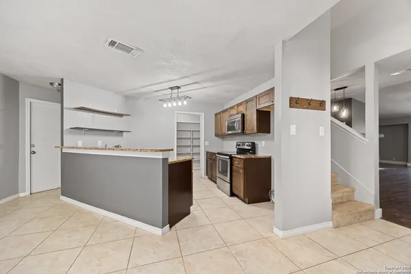 a kitchen with stainless steel appliances kitchen island granite countertop a refrigerator and a stove