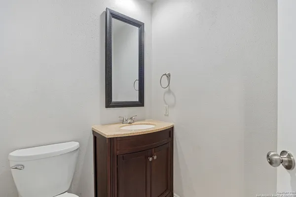 a bathroom with a toilet a sink and mirror
