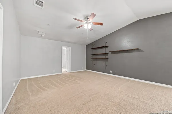 a view of an empty room with a ceiling fan