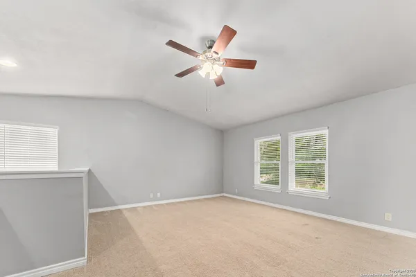 an empty room with window and ceiling fan