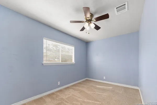 a view of a big room with windows and chandelier fan