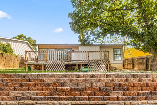a front view of a house with large trees