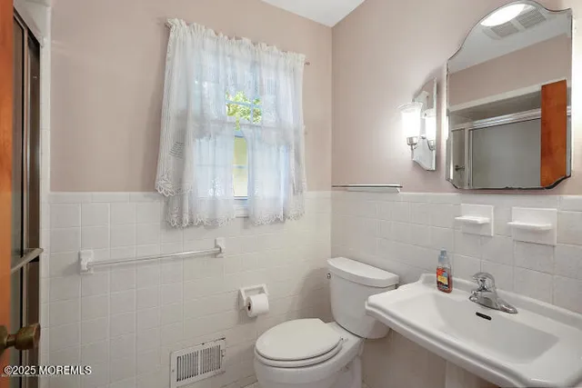 a bathroom with a sink a toilet and mirror