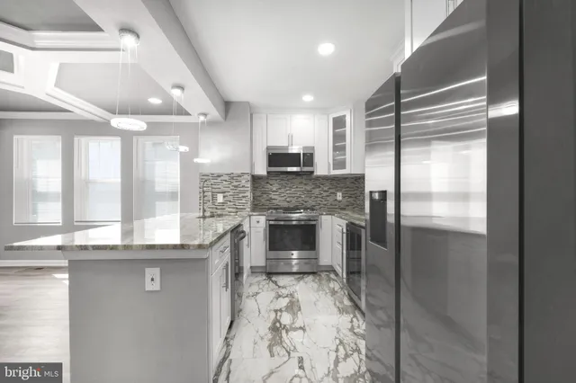 a kitchen with granite countertop a refrigerator and a counter top space