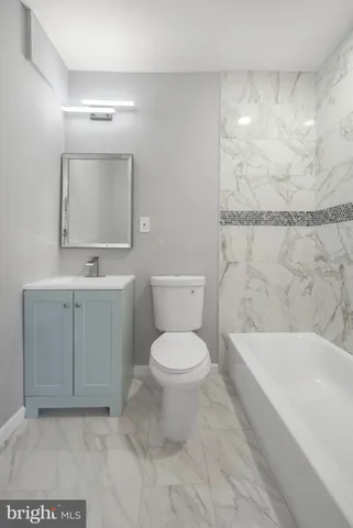 a bathroom with a toilet a sink and mirror
