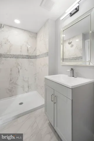 a bathroom with a bathtub a mirror a sink and vanity