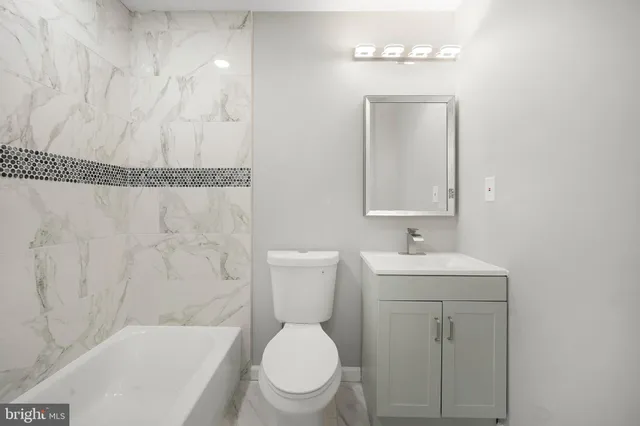 a bathroom with a toilet a sink and mirror