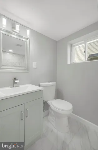 a bathroom with a toilet a sink and mirror