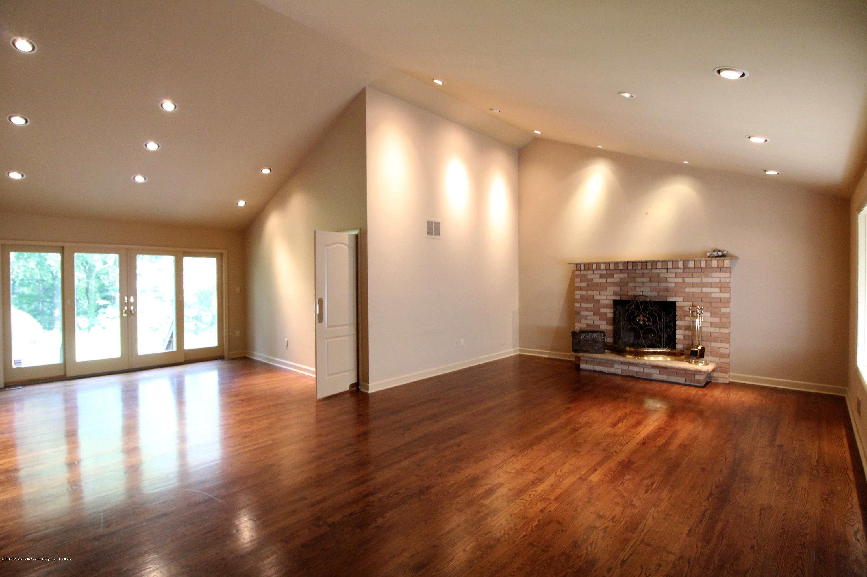 134 Conover Road Morganville, NJ 07751 - Photo 1 of 24 a view of an empty room with wooden floor and a fireplace