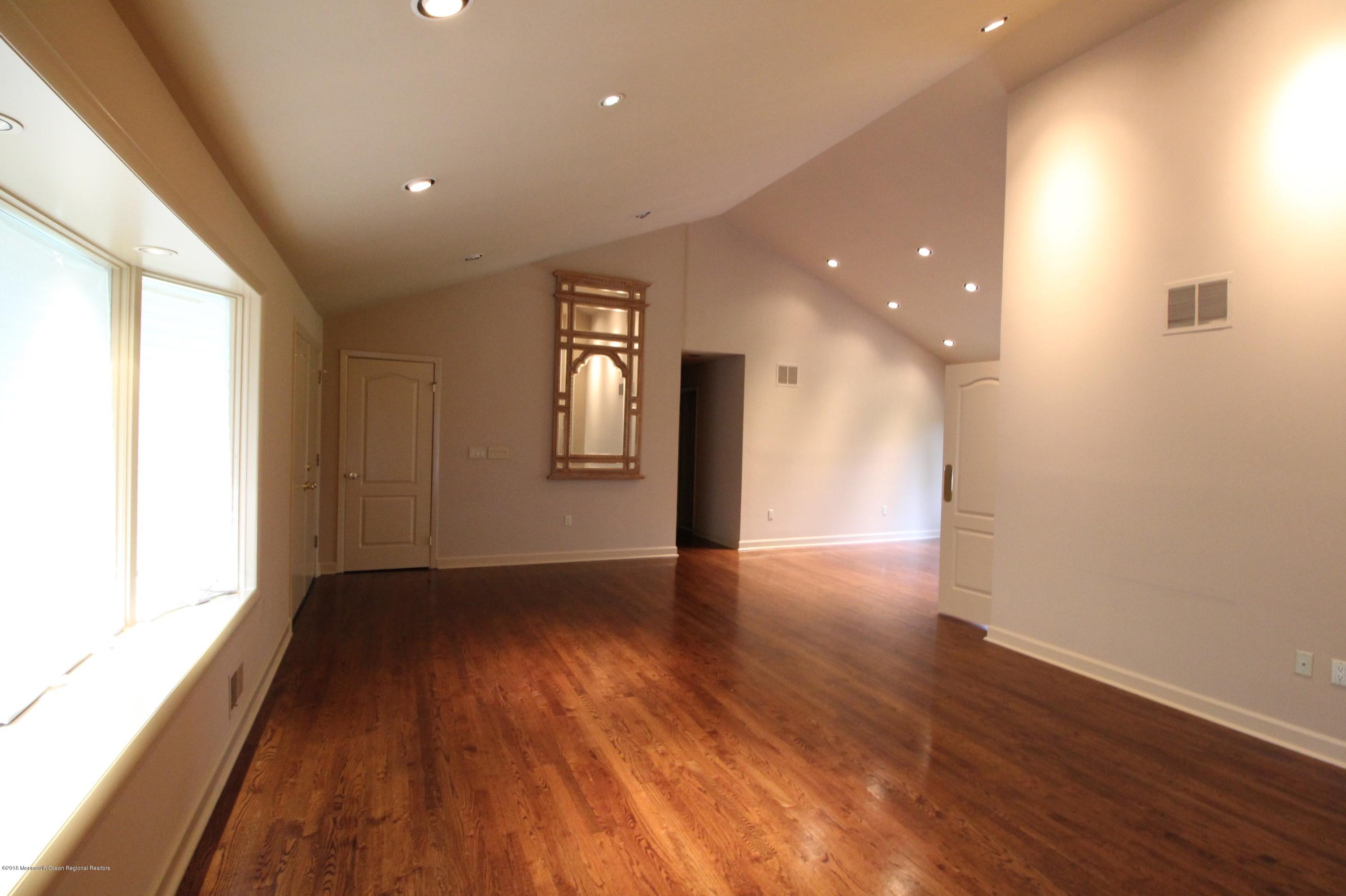 134 Conover Road Morganville, NJ 07751 - Photo 3 of 24 an empty room with wooden floor and windows