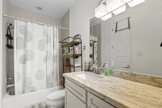 a bathroom with a granite countertop sink toilet and shower