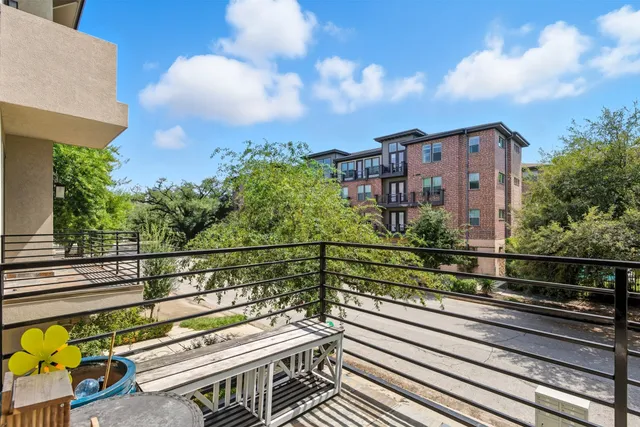 a view of a balcony with two chairs and a potted plant
