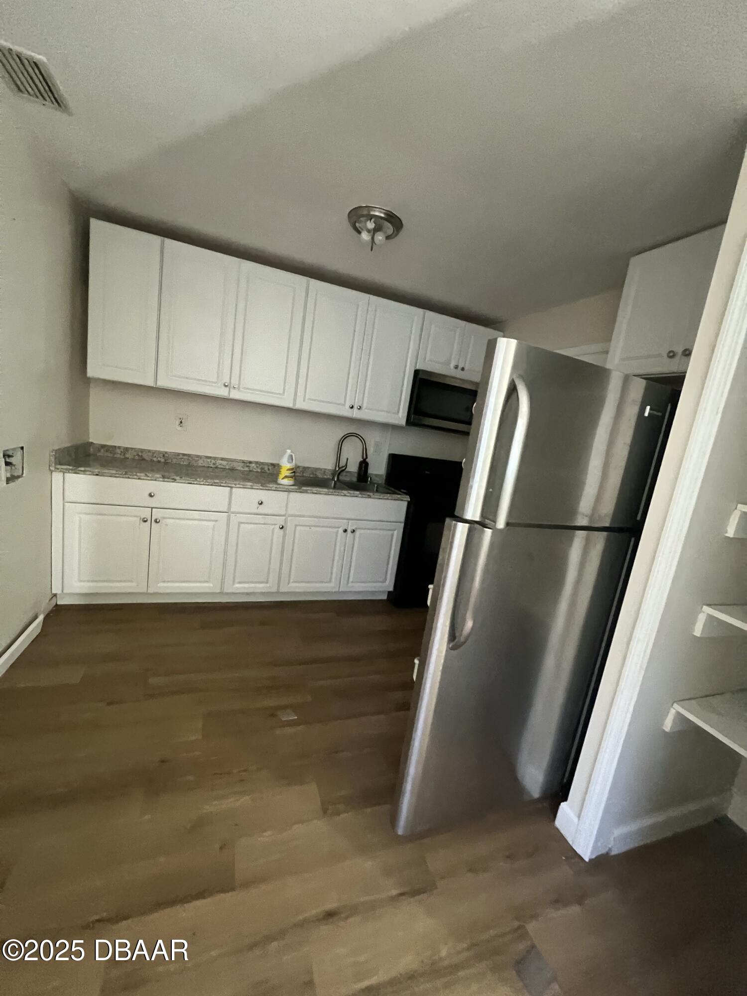 536 Ruth Street Daytona Beach, FL 32114 - Photo 6 of 10 a kitchen with stainless steel appliances granite countertop a refrigerator a stove and a sink with wooden floor