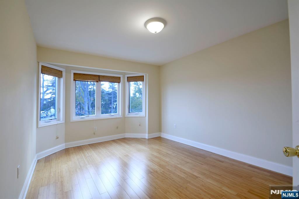 12 Pulaski Place, Unit A Hackensack, NJ 07601 - Photo 17 of 29 an empty room with wooden floor and windows