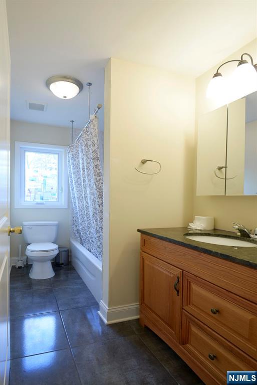12 Pulaski Place, Unit A Hackensack, NJ 07601 - Photo 19 of 29 a spacious bathroom with a granite countertop sink a toilet and a mirror